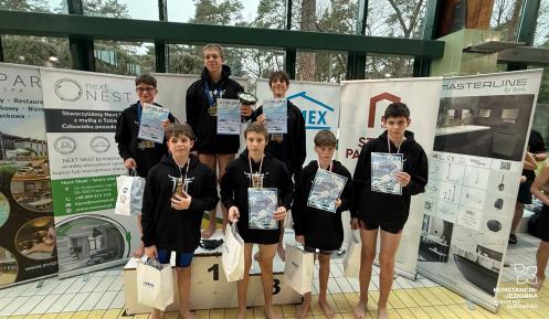 pływacy w ciemnych koszulkach na podium