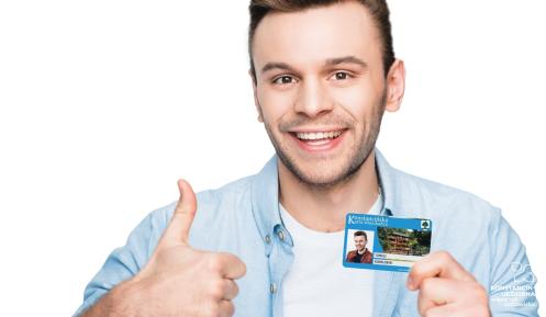 Uśmiechniety mężczyzna trzyma kartę mieszkańca i trzyma kciuk w górę.