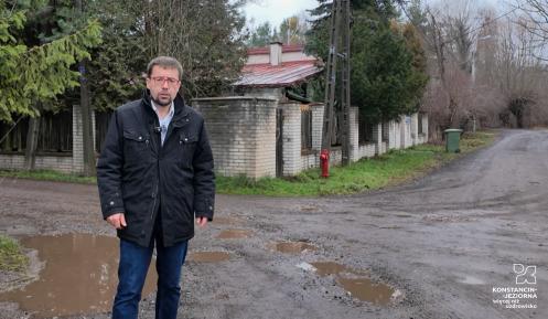 Meżczyzna stoi na nieutwardzonej drodze 