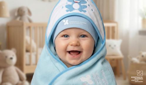 Uśmiechnięte dziecko owinięte w niebieski kocyk