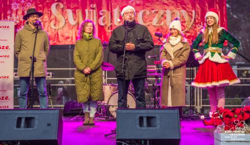 Grupa osób stoi na scenie i składa życzenia mieszkańcom