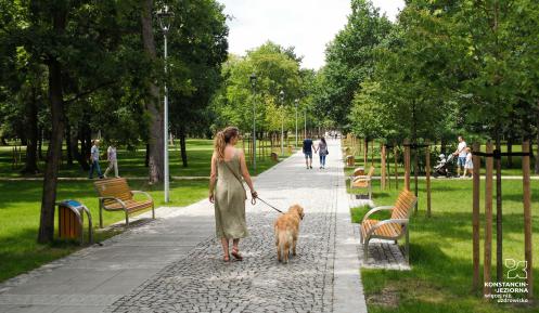Kobieta prowadząca na smyczy psa w Parku Zdrojowym