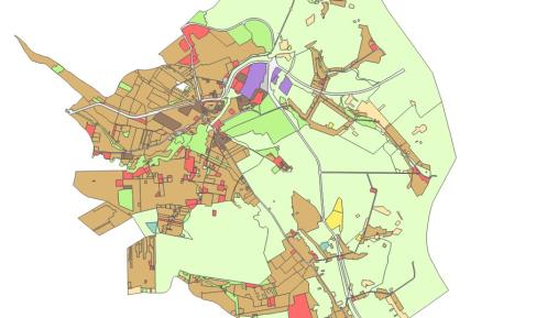 Mapa planistyczna gminy przedstawiająca zróżnicowane przeznaczenie terenów w formie kolorowych stref, z dominującą zabudową w części centralnej oraz rozległymi obszarami zielonymi na obrzeżach.