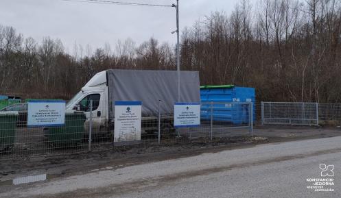 Ogrodzony teren PSZOK-u przy ul. Mirkowskiej z zaparkowaną ciężarówką i kontenerami na odpady w tle drzew.