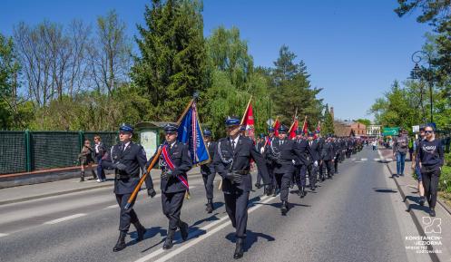 Strażacy ochotnicy maszerują w uroczystej paradzie ulicami Konstancina-Jeziorny podczas obchodów Dnia Strażaka.