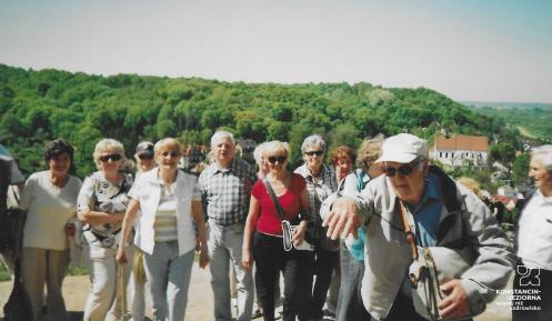 Grupa seniorów pozuje do zdjęcie w krajobrazie wyżynnym