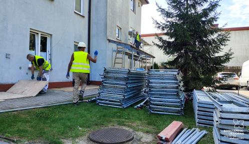 Pracownicy przygotowują rusztowanie przy budynku mieszkalnym przy ul. Koziej 1C w Konstancinie-Jeziornie. Prace związane są z rozpoczynającą się termomodernizacją obiektu.