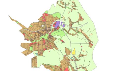Mapa planistyczna gminy przedstawiająca zróżnicowane przeznaczenie terenów w formie kolorowych stref, z dominującą zabudową w części centralnej oraz rozległymi obszarami zielonymi na obrzeżach.