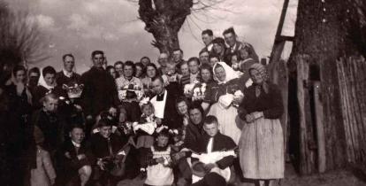 Stare zdjęcie czarno-białe, duża grupa osób ubranych w odświętne stroje z koszykami wielkanocnymi