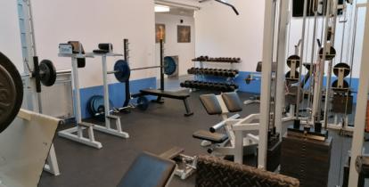 Wnętrze pomieszczenia z urządzeniami do ćwiczeń fizycznych.