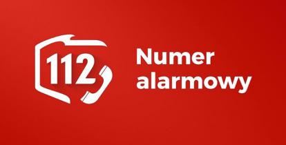 Czerwony prostokąt, a na nim biały kontur Polski z numerem 112 oraz ikonką słuchawki telefonicznej. Obok nich napis: numer alarmowy.