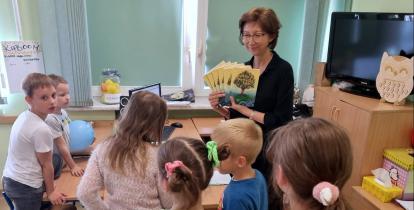 Dyrektorka Szkoły Podstawowej nr 3 Katarzyna Hampel stoi w klasie wśród uczniów, trzyma w ręku książki.