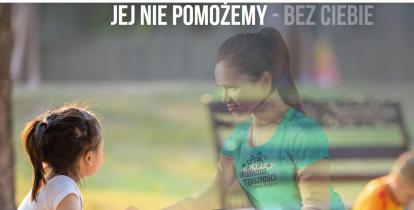 Dziewczynka siedzi na ławce w parku. Naprzeciwko niej znajduje się dorosła kobieta, która trzyma ją za dłoń. 