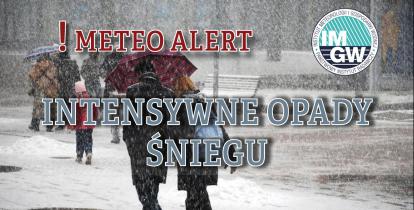 Na górze czerwony napis meteo alert poprzedzony wykrzyknikiem. Obok niego logo Instytutu Meteorologii i Gospodarki Wodnej - niebieski okrąg z białymi literami IMGW, poniżej szary napis intensywne opady śniegu. W tle widać ludzi idących chodnikiem. Pada na nich śnieg. 