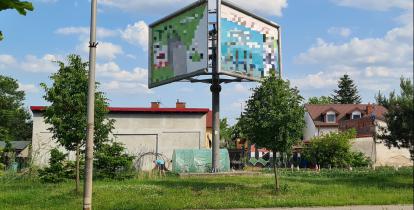 Przestrzeń miejska. Przy ulicy stojący billboard reklamowy. 