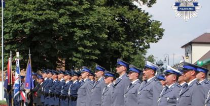 Funkcjonariusze w umundurowaniu stoją na baczność w rzędzie. 