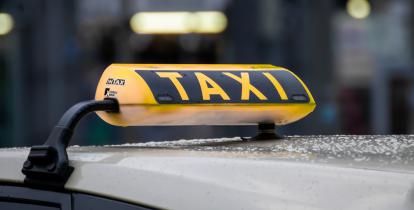 zdjęcie dachu białego samochodu z żółtym wyświetlaczem taxi 