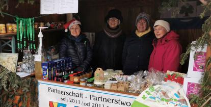 Zdjęcie stoiska z herbem Konstancina-Jeziorny, Za lada cztery kobiety. Na ladzie artykuły spożywcze.