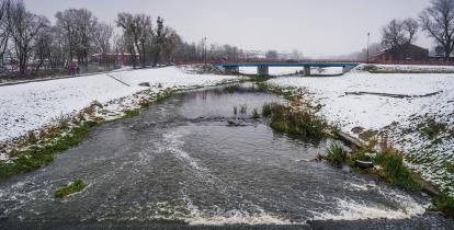 Rzeka Jeziorka płynaca obok Starej Papierni zimą.