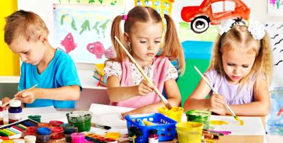 Troje dzieci maluje farbkami obrazek