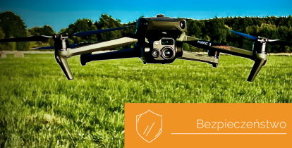 Dron z kamerą nad polaną, w tle drzewa