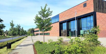 Wysoki budynek z czerwonej cegły z przeszklonymi oknami