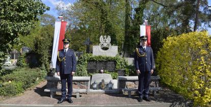 Kwatera na cmentarzu orodzona niskim murkiem. Na niej wieńce, a przed nia zapalone znicze.