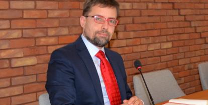 Burmistrz na tle ściany z czerwonej cegły.