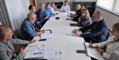 Grupa osób siedzi przy stole. 