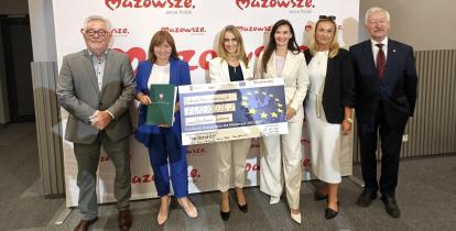 Grupa ludzi trzyma czek