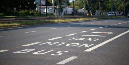 Fragment ulicy z wydzielonym pasem ruchu oznaczonym jako buspas, przeznaczonym dla autobusów, taksówek i motocykli.