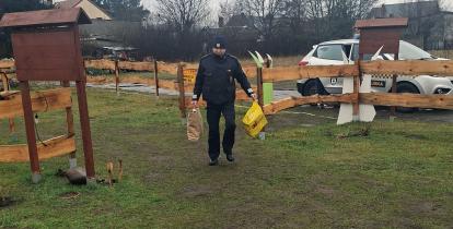 Strażnik miejski niosący reklamówi w darami.