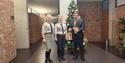 harcerki oraz burmistrz stoją w korytarzu ratusza trzymając zapalony drewniany lampion