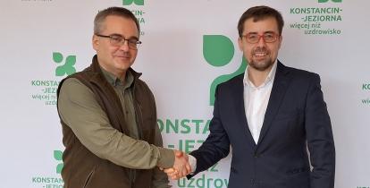 Dwie osoby podają sobie rękę z gratulacjami