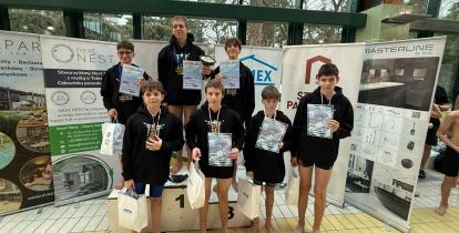 pływacy w ciemnych koszulkach na podium