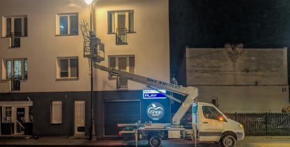 Samochód z podnośnikiem montuje dekoracje świąteczne na latarniach