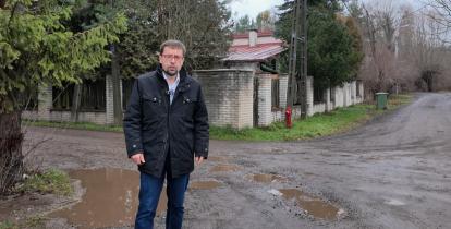 Meżczyzna stoi na nieutwardzonej drodze 