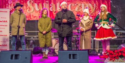 Grupa osób stoi na scenie i składa życzenia mieszkańcom