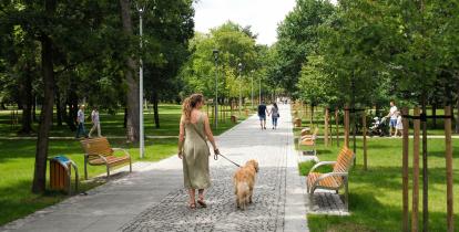 Kobieta prowadząca na smyczy psa w Parku Zdrojowym