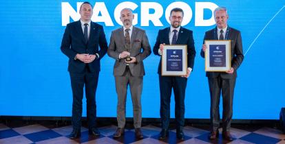Na scenie gali wręczenia nagród przedstawiciele samorządów pozują z dyplomami i statuetką przy tle z napisem „Gala wręczenia nagród”.