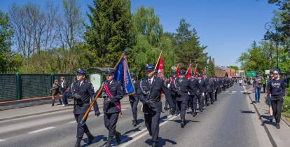 Strażacy ochotnicy maszerują w uroczystej paradzie ulicami Konstancina-Jeziorny podczas obchodów Dnia Strażaka.