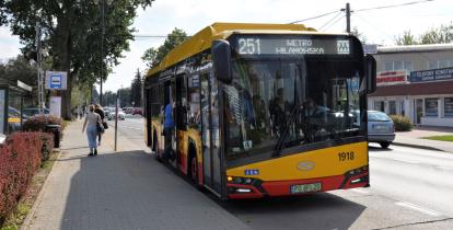 Autobus linii 251 z napisem Metro Wilanowska stojący na przystanku autobusowym.