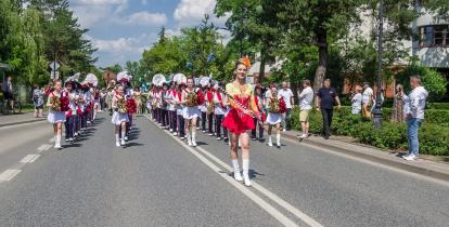 Parada z udziałem orkiestry i mażoretek przemierza ulicę podczas miejskiego święta w Konstancinie-Jeziornie.