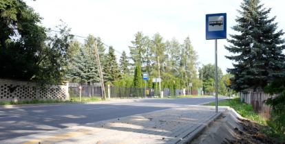 Na zdjęciu widoczny jest nowy przystanek autobusowy „Czernidła-Dom Ludowy”. Przy utwardzonym peronie ustawiono słupek z oznaczeniem przystanku, a obok znajduje się jezdnia otoczona drzewami i zabudową jednorodzinną. Przystanek został przygotowany do obsługi pasażerów komunikacji publicznej