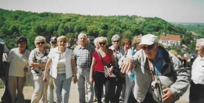 Grupa seniorów pozuje do zdjęcie w krajobrazie wyżynnym