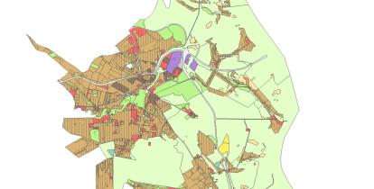 Mapa planistyczna gminy przedstawiająca zróżnicowane przeznaczenie terenów w formie kolorowych stref, z dominującą zabudową w części centralnej oraz rozległymi obszarami zielonymi na obrzeżach.