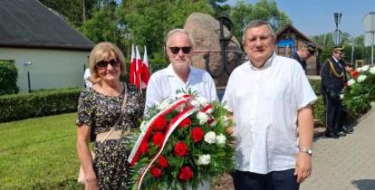Trzyosobowa delegacja Rady Seniorów Gminy Konstancin-Jeziorna – Alfreda Konopka, Wojciech Guszkowski i Grzegorz Rutkowski – stoi z wieńcem biało-czerwonych goździków przed pomnikiem pamięci z symbolem Polski Walczącej podczas obchodów rocznicy Powstania Warszawskiego.