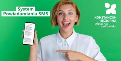 Uśmiechnięta młoda kobieta na zielonym tle trzyma w dłoni smartfon z wiadomościami SMS i wskazuje na niego palcem. Na grafice widnieje napis „System Powiadamiania SMS” oraz logo „Konstancin-Jeziorna więcej niż uzdrowisko”.