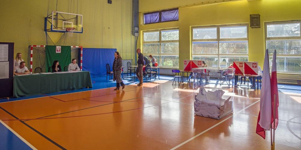Sal gimnastyczna ze stojącą na jej środku urną wyborczą.