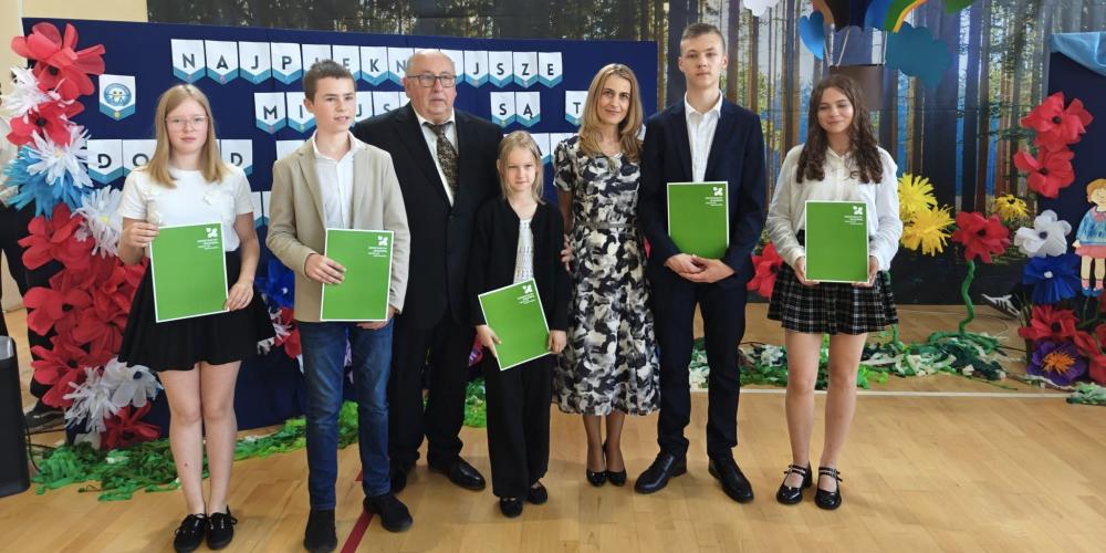 Uczniowie wyróżnieni tytułem „Młody Mistrz Nauki 2025” podczas uroczystości zakończenia roku szkolnego w jednej z konstancińskich szkół, w towarzystwie przedstawicieli gminy.